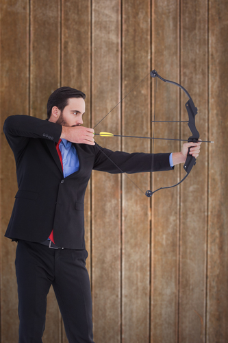 man taking aim with a bow and arrow